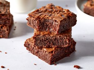 Side view of three brownies stacked on top of each other with a bite bitten from the brownie at the top