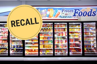 Freezer section in a store with a recall notice sign placed in the image