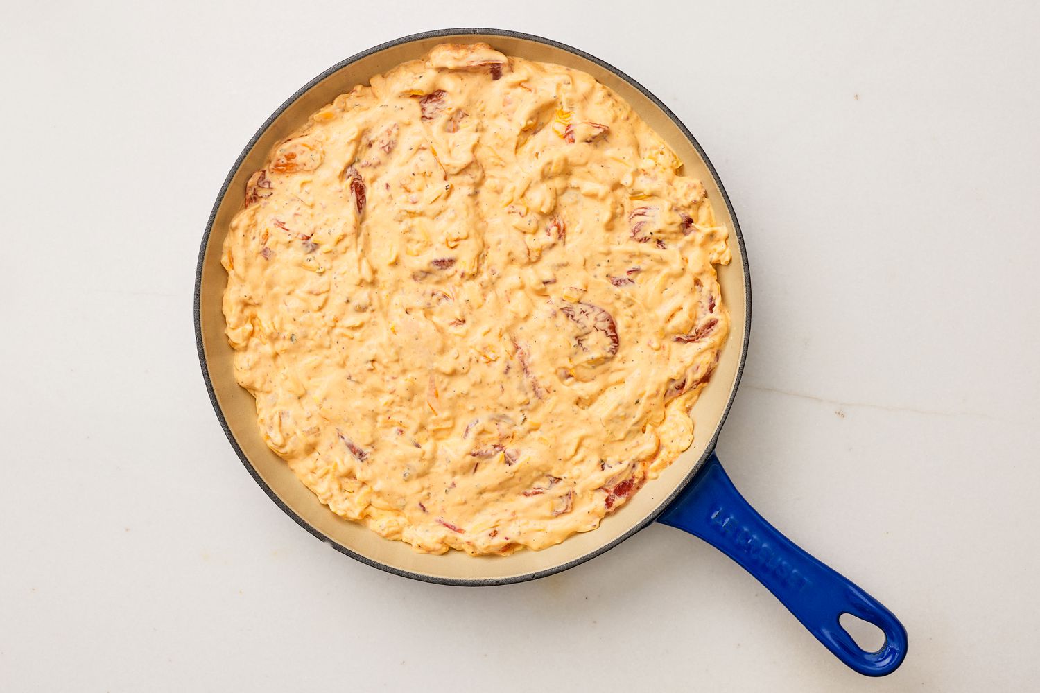 tomato pie dip filling added to a pan 