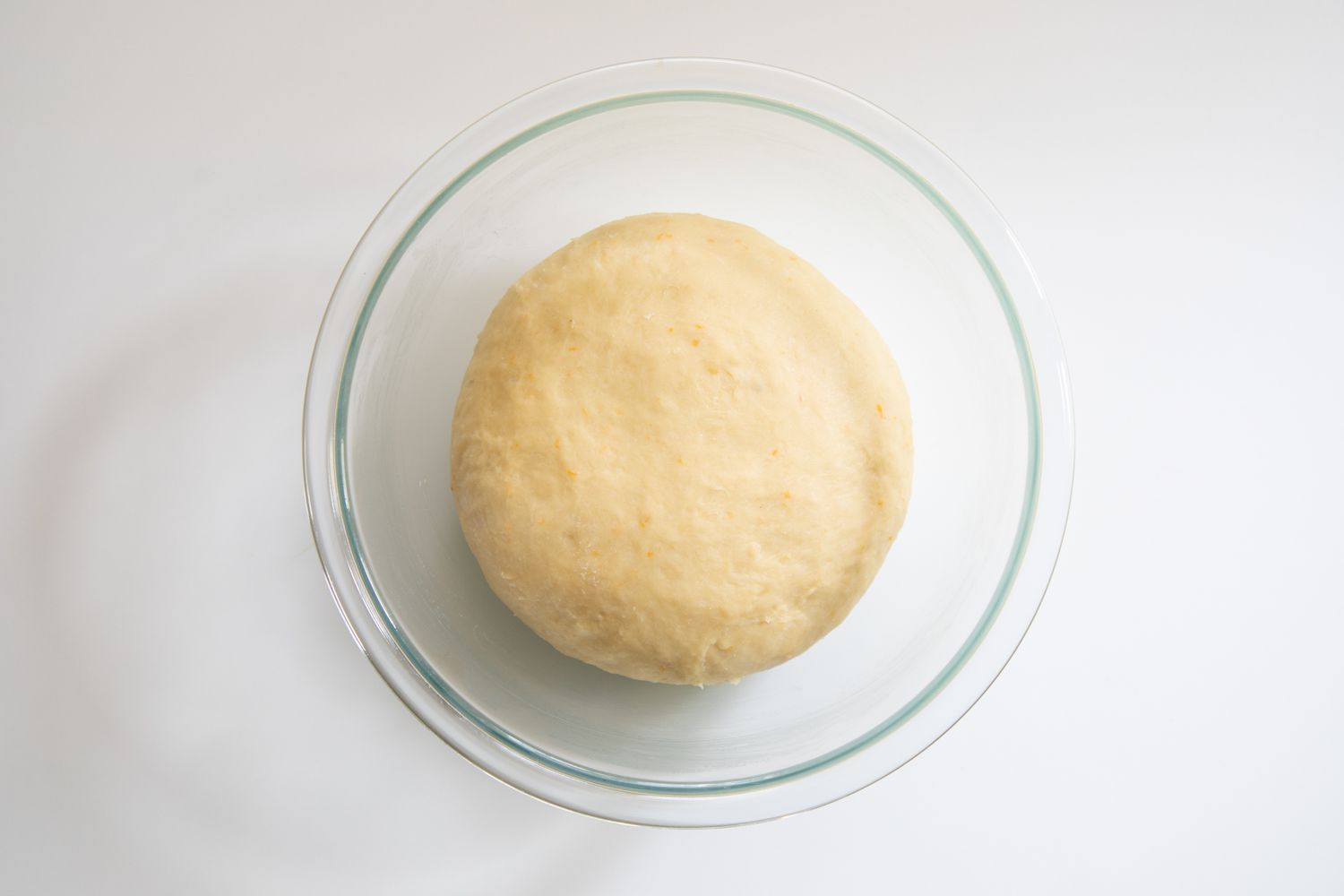 Risen dough in a bowl to make a sticky buns recipe.