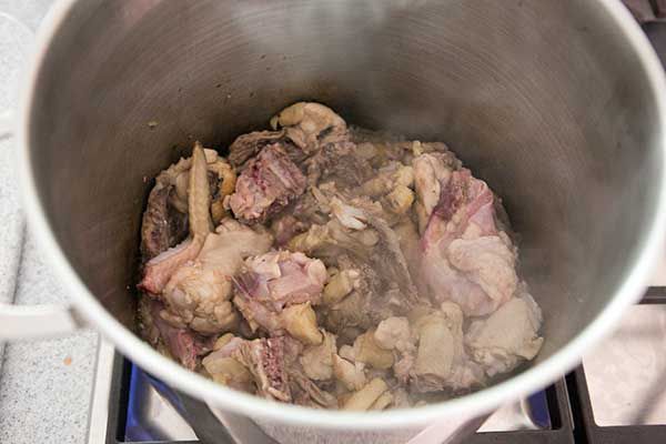 Chicken pieces cooking in a stock pot