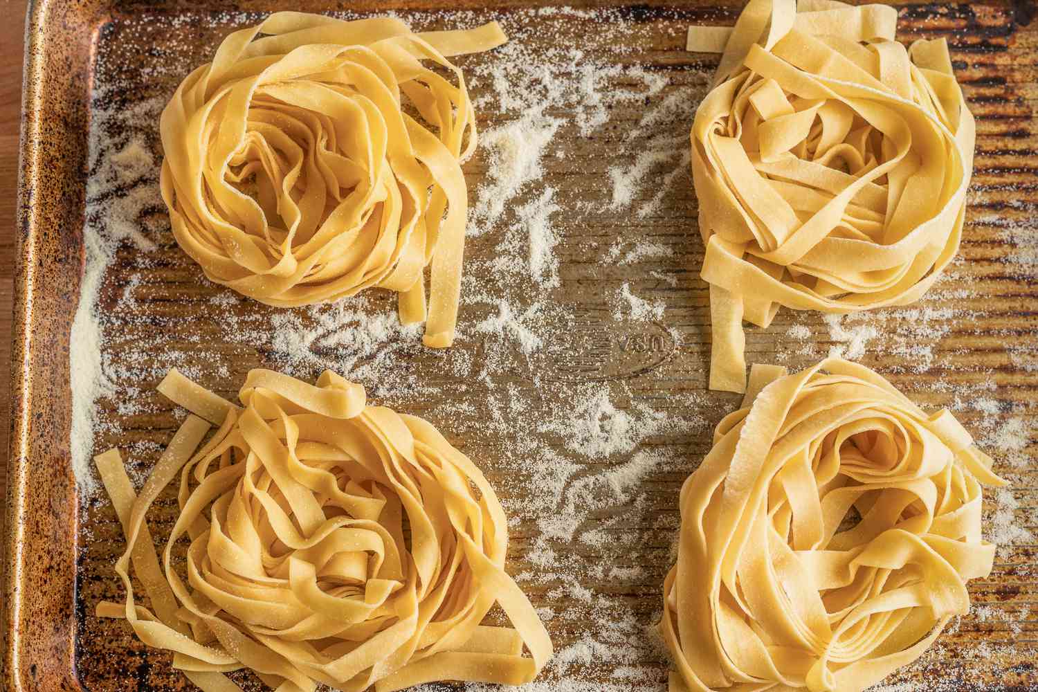 Four Bundles of Homemade Tagliatelle on a Semolina Dusted Baking Sheet 
