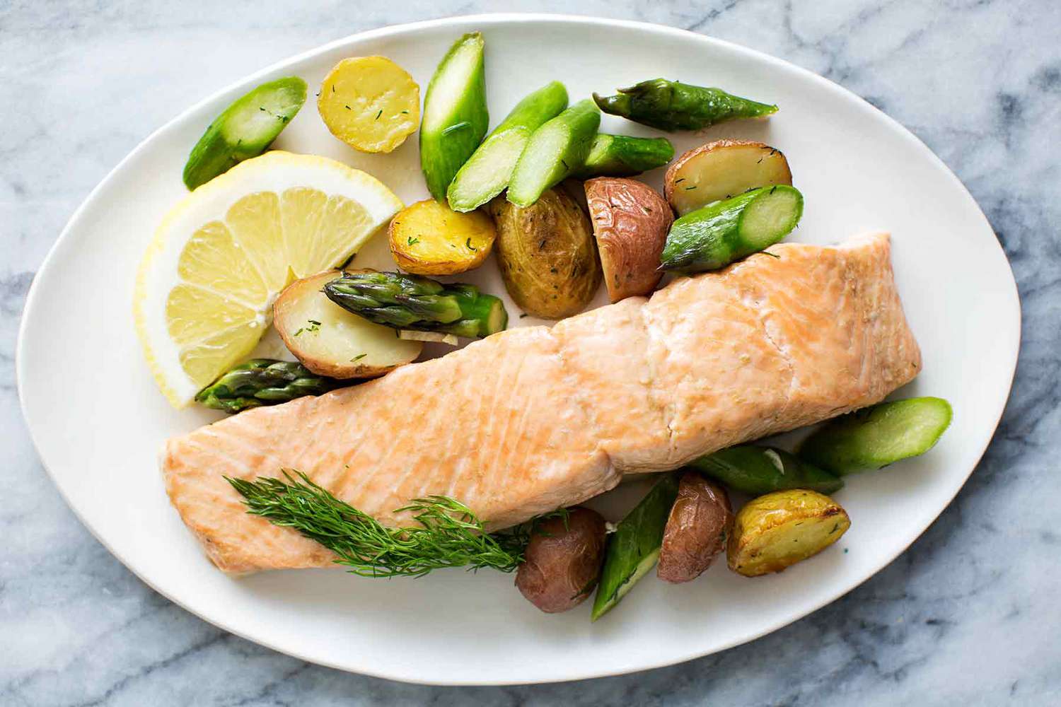 oven-roasted salmon and spring vegetables on white plate