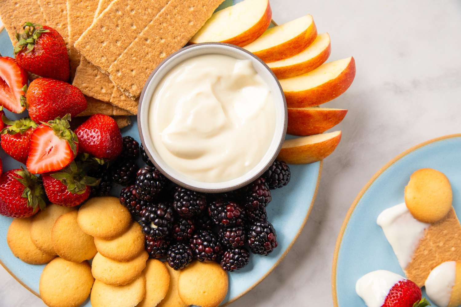 Plate of cheesecake dip with fruits graham crackers and cookies