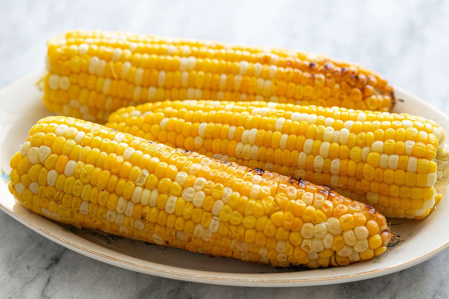 Grilled corn on the cob served on an oval platter