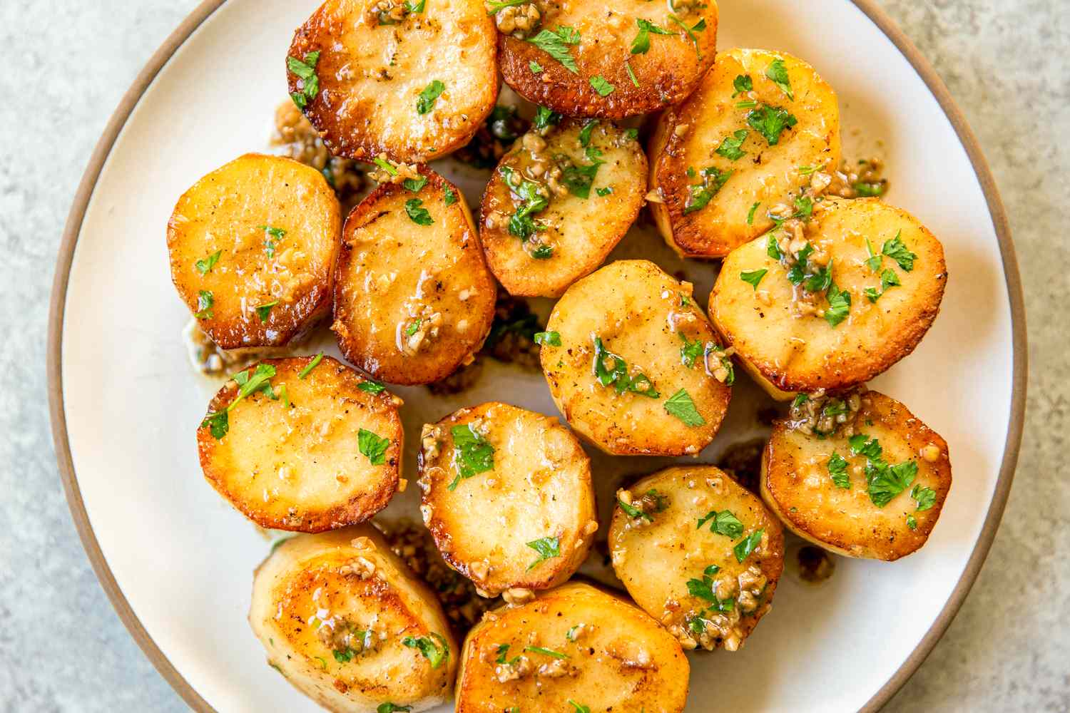 A plate of garlic melting potatoes garnished with herbs