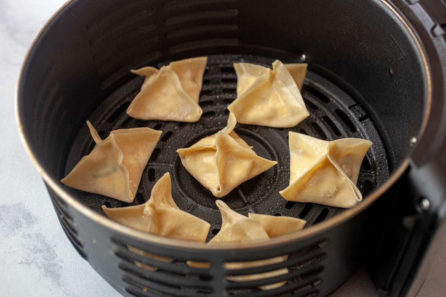Cream cheese wontons placed in the air fryer