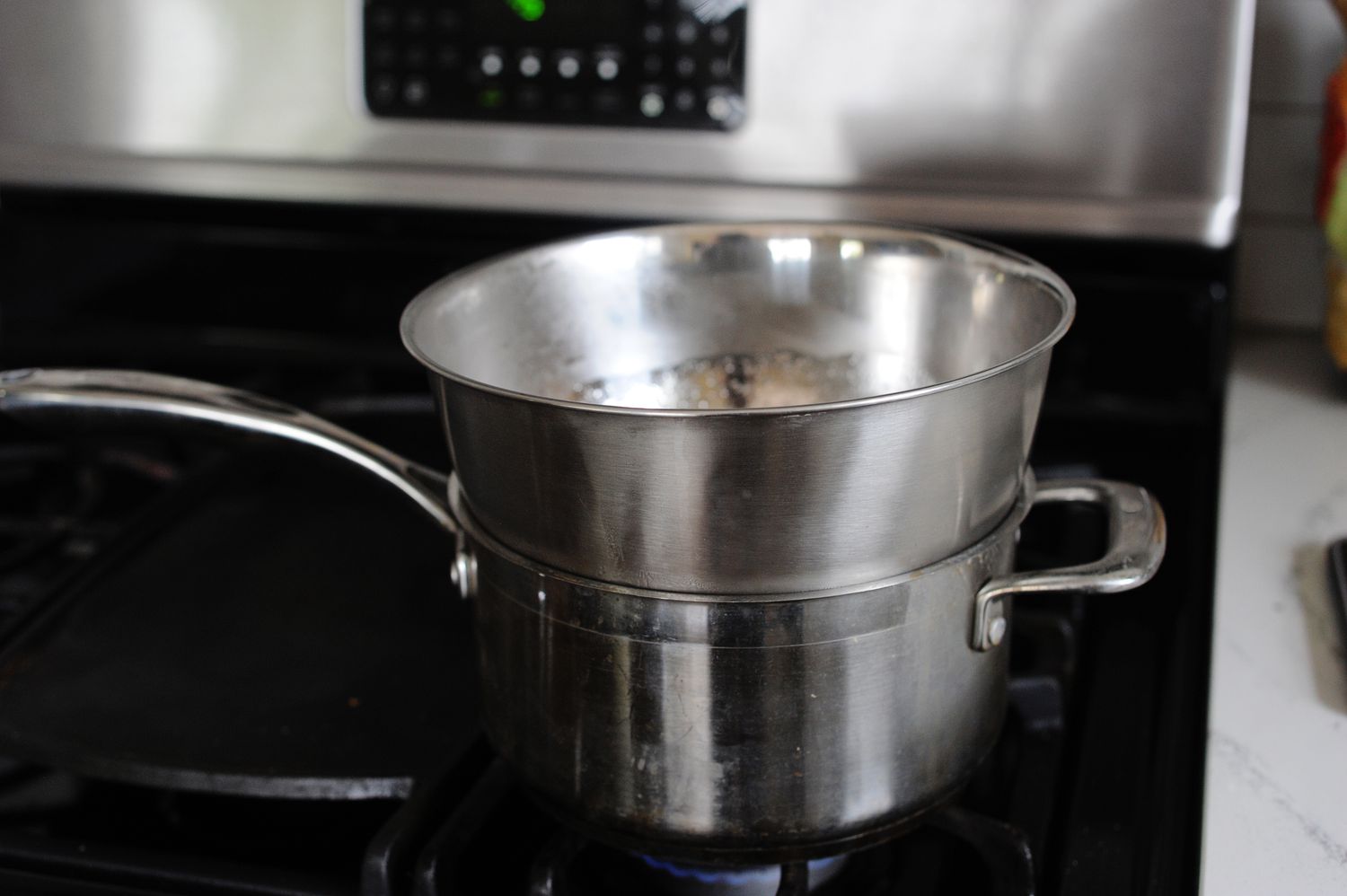 A bowl set inside a pot to make Strawberry Seven-Minute Frosting.