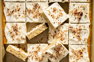 Banana bars with frosting and sprinkled nuts arranged in a grid
