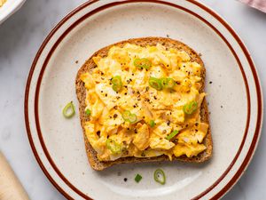Overhead view of a toast topped with kimchi egg salad and sliced scallions