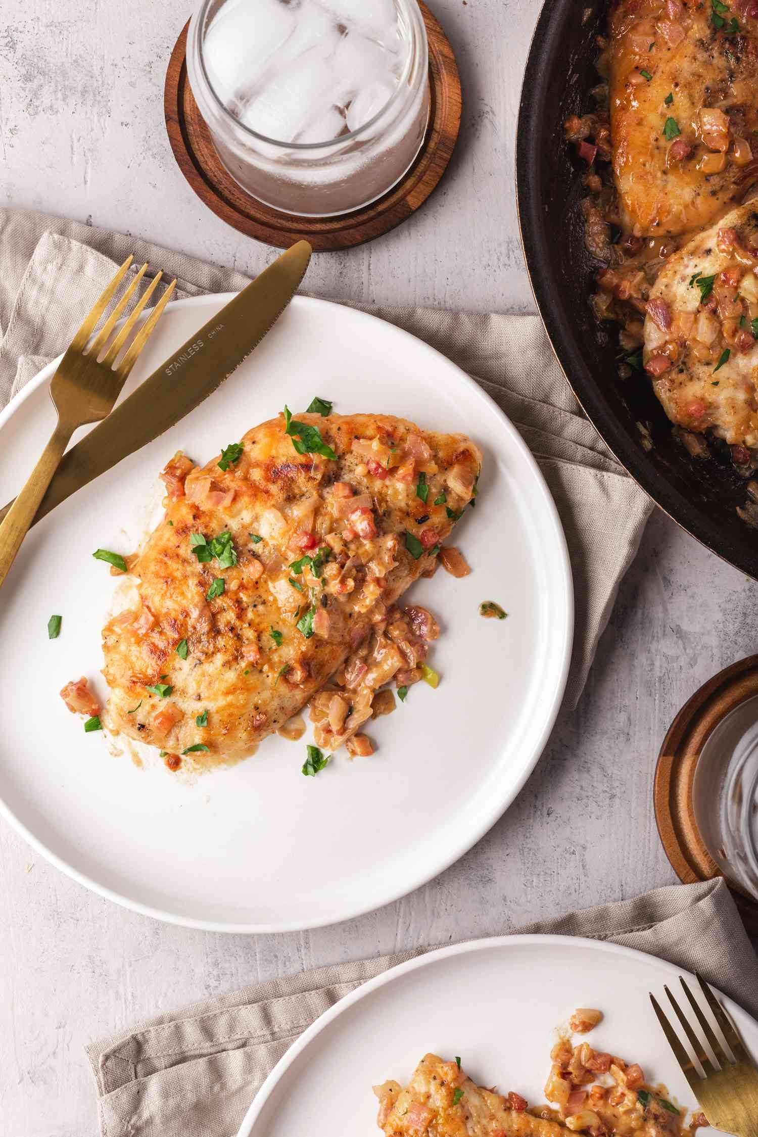 A table set with easy chicken marsala, drinks, and silvereware.