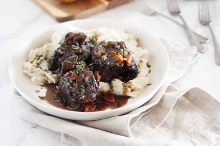 Mashed potatoes and short ribs on a plate.
