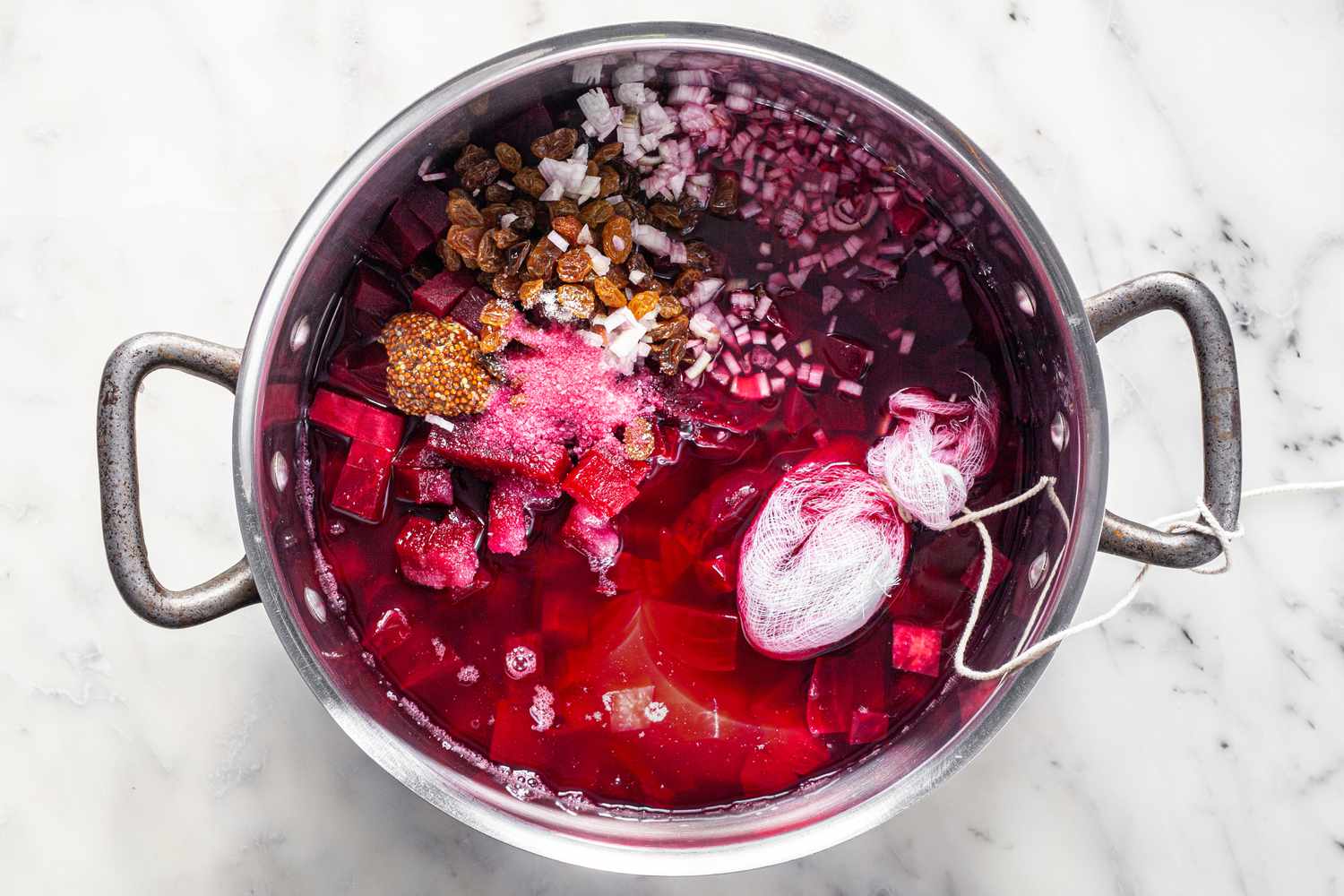 Cubed Beets, Shallots, Mustard, Golden Raisins, and Cheesecloth with Spices in a Pot of Brine for Beet Chutney Recipe