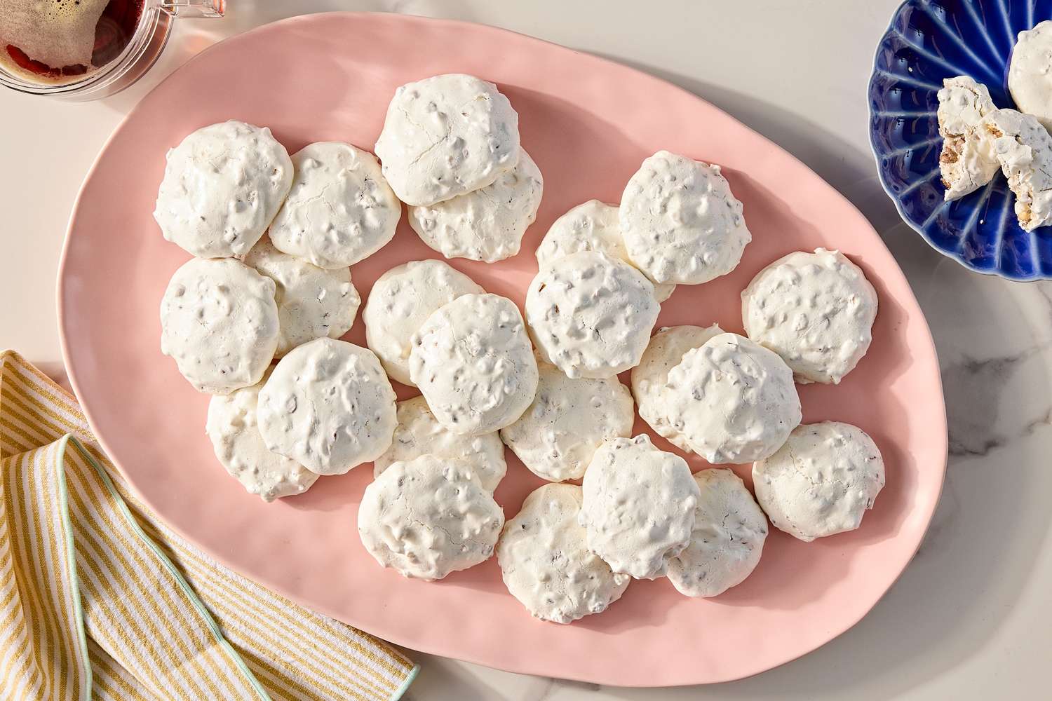 A pink plate with several round meringue cookies