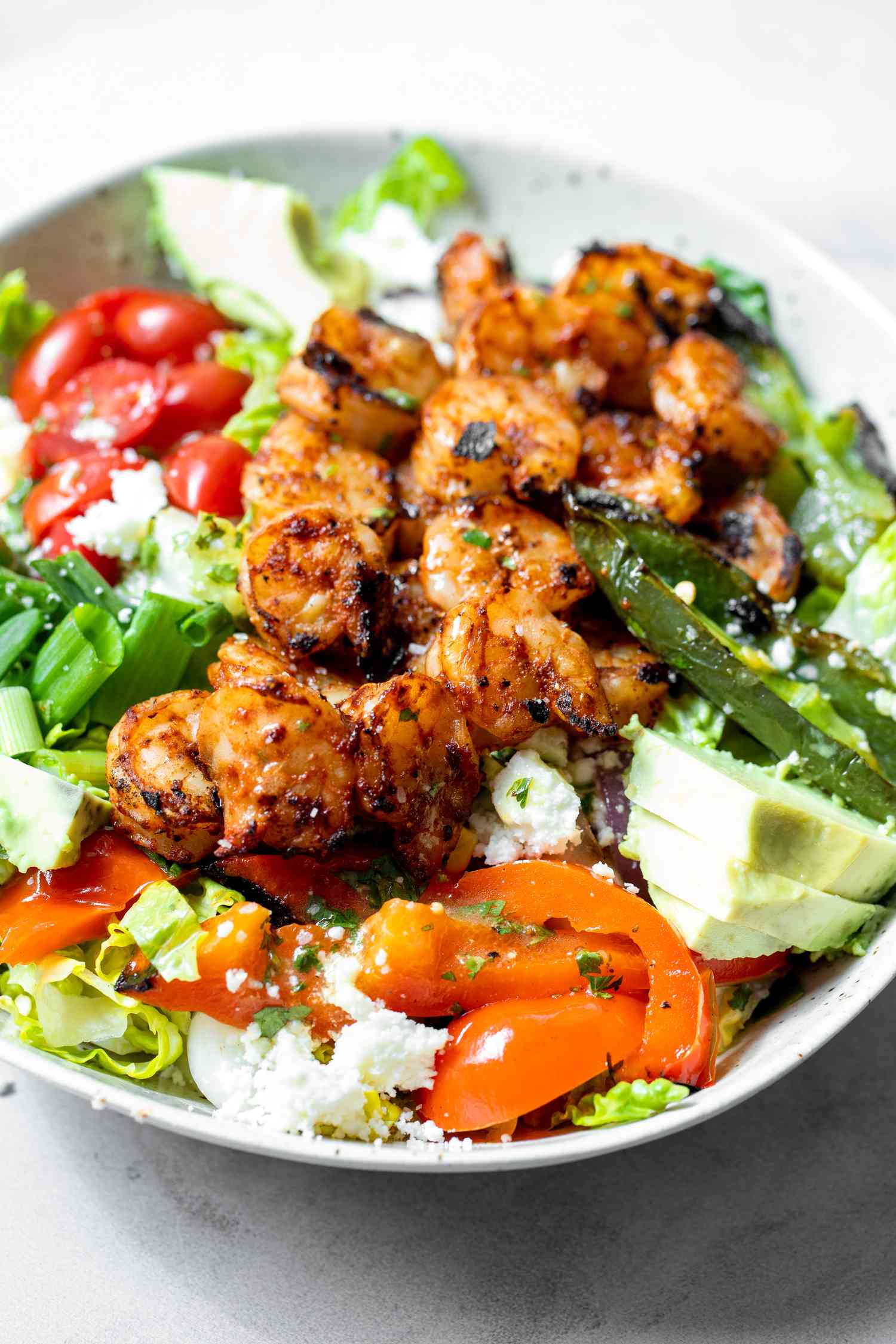 Bowl of Grilled Shrimp Salad with Shrimp, Avocados, Cherry Tomatoes, and Cotija Cheese