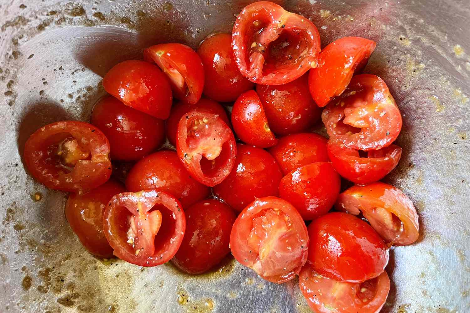 Cherry tomatoes coated with dressing in a bowl