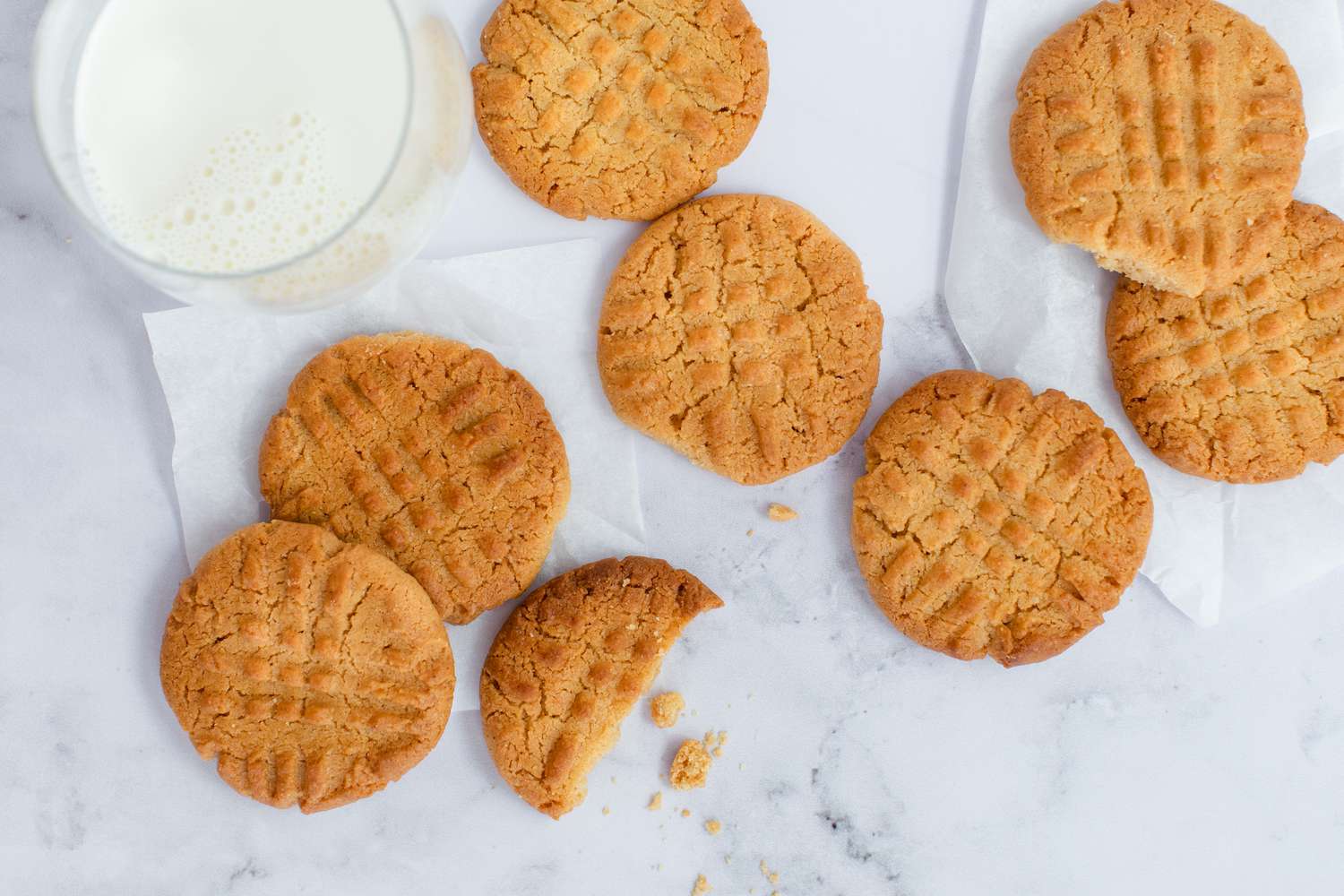 A glass of milk with Peanut Butter Cookies on a white background.