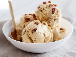 Four scoops of butter pecan in a shallow bowl.
