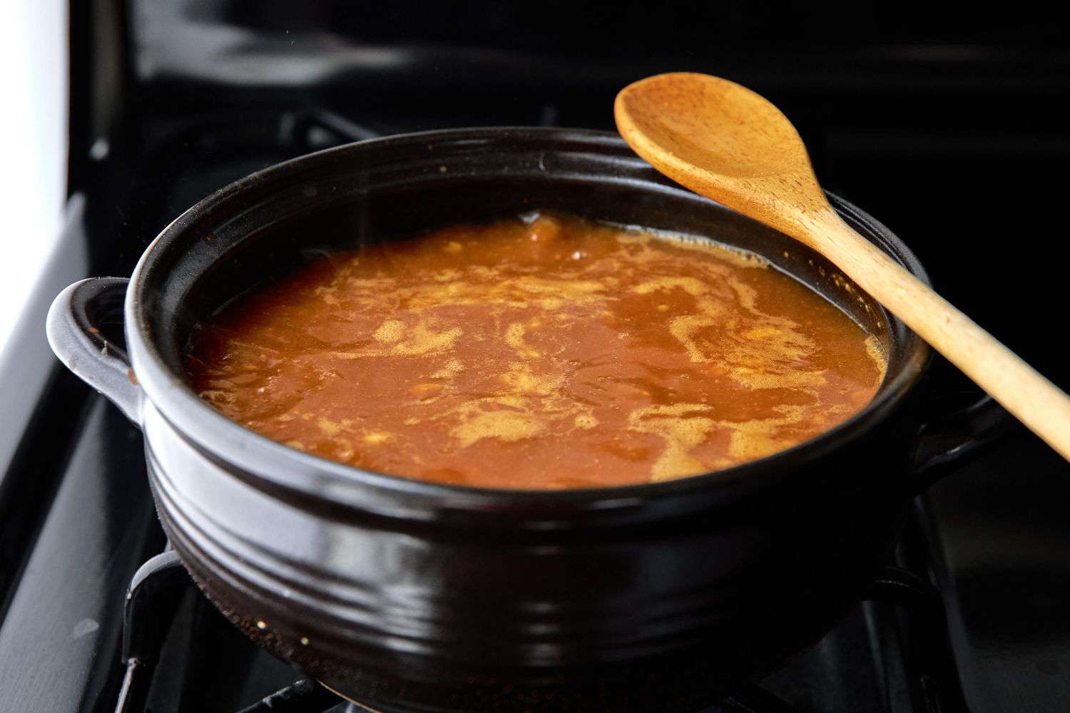 Doenjang Added to Clay Pot of Filled With Anchovy Broth on the Stove for Doenjang Jjigae Recipe