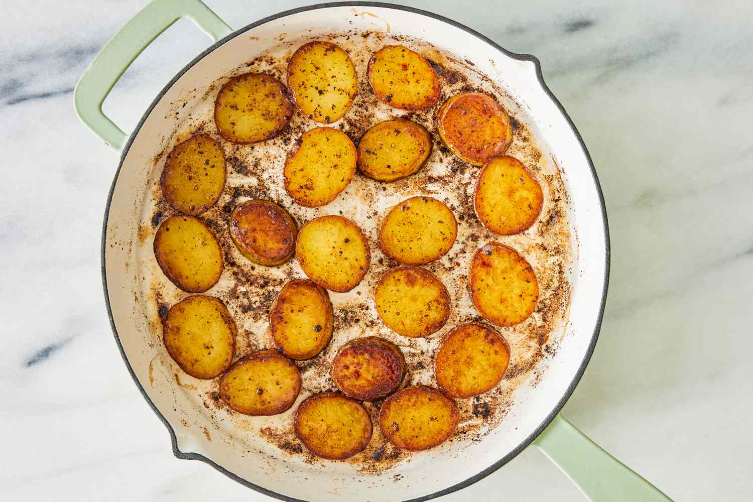 Sliced potatoes browned in a skillet for the for the miso melting potatoes recipe