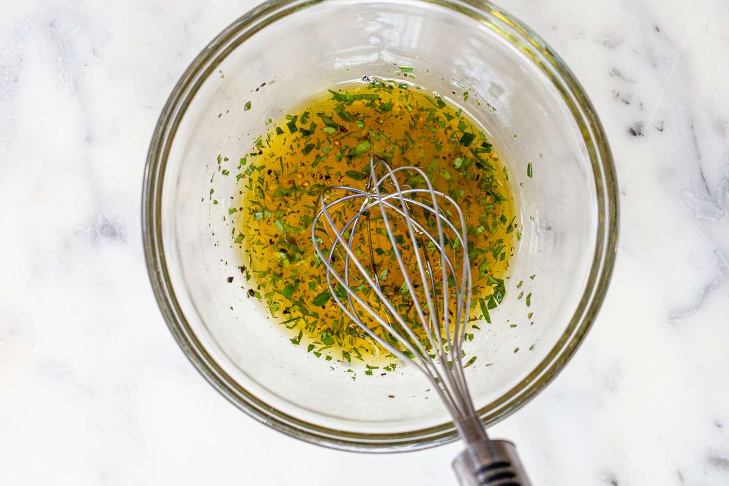 Whisking the dressing to make a grilled romaine salad.