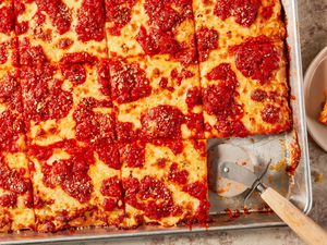 Grandma Pizza in a baking sheet cut into square pieces 