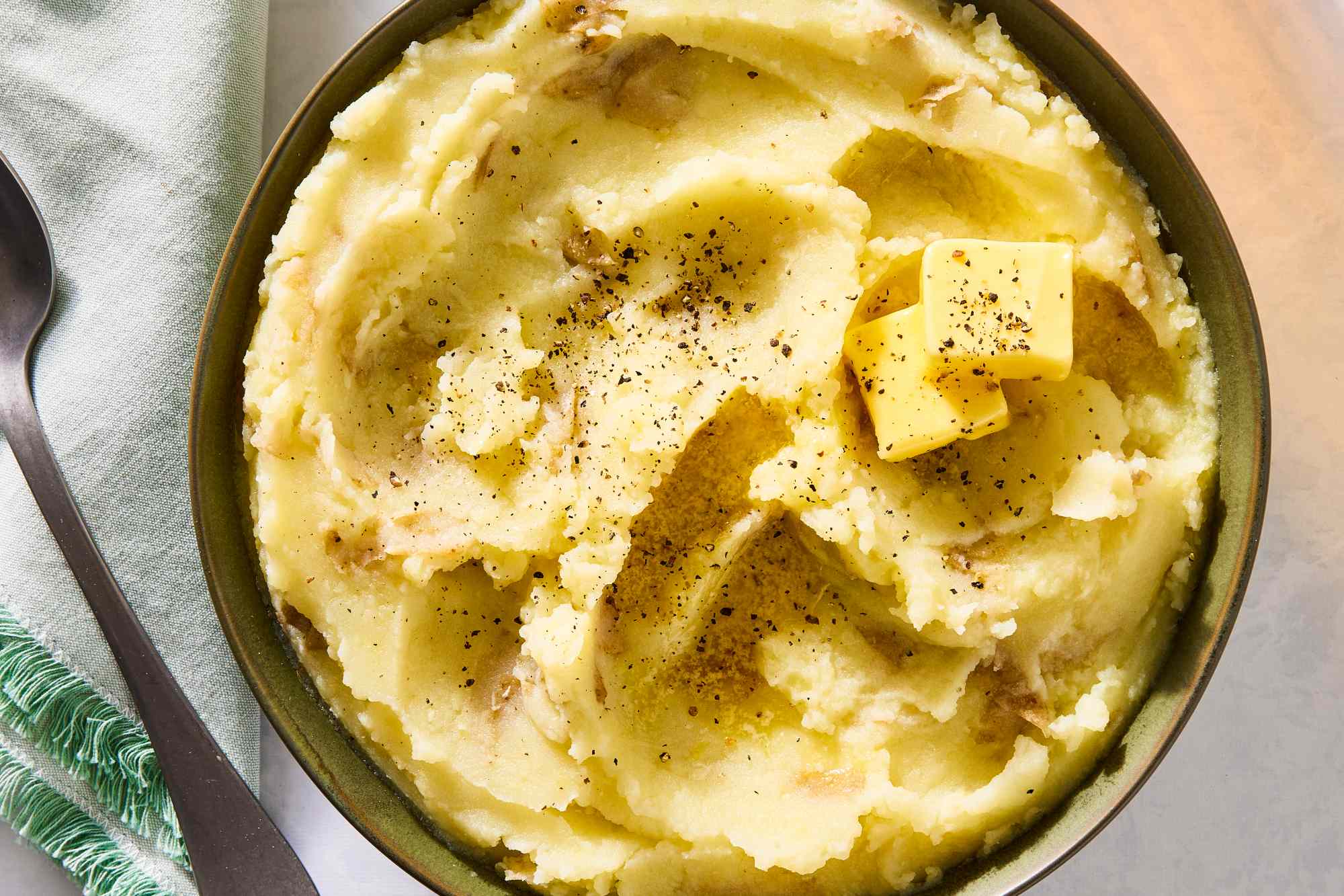 Garlic mashed potatoes with butter on top served in a bowl