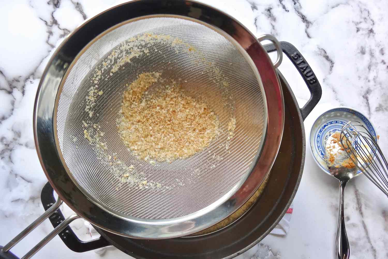 Whisking miso into broth to make miso soup.