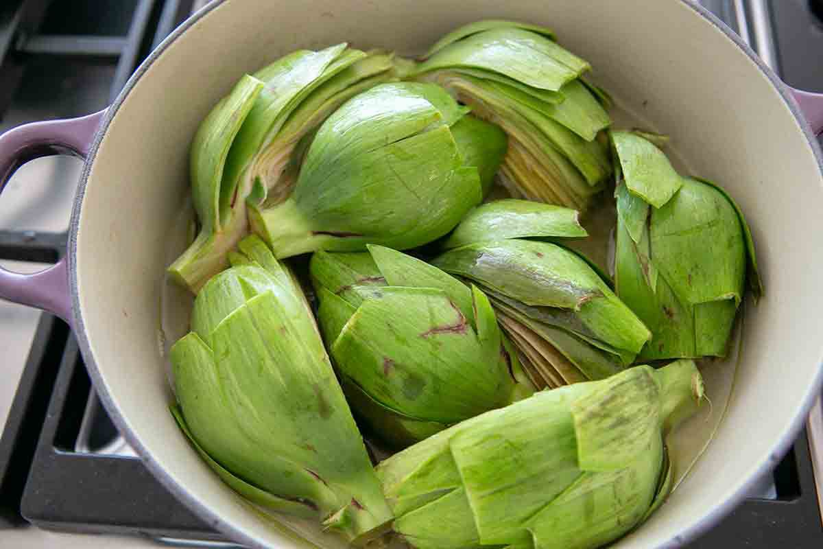 add artichokes to shallots in a pot