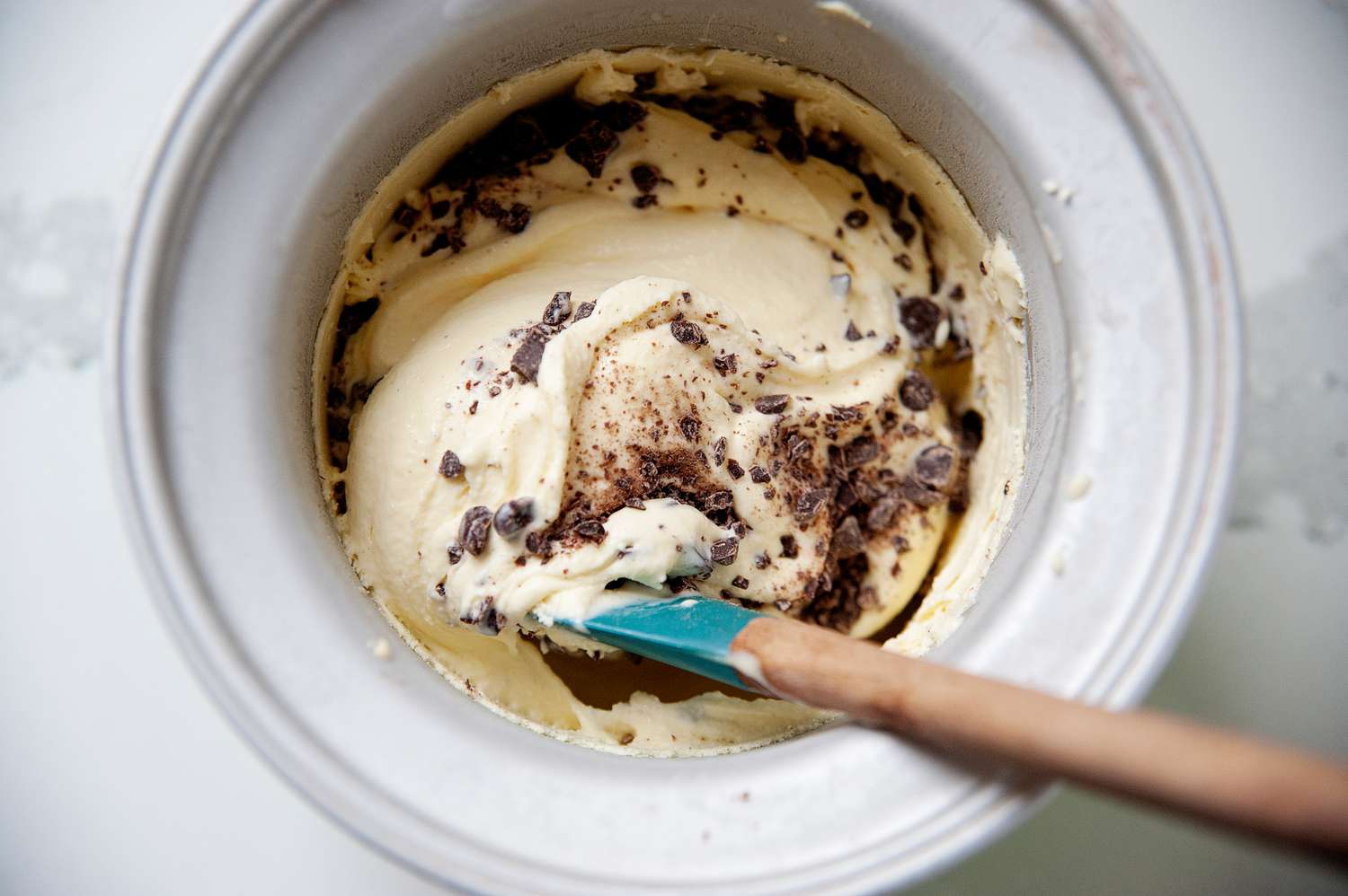 Stirring chocolate chips into the mint ice cream.