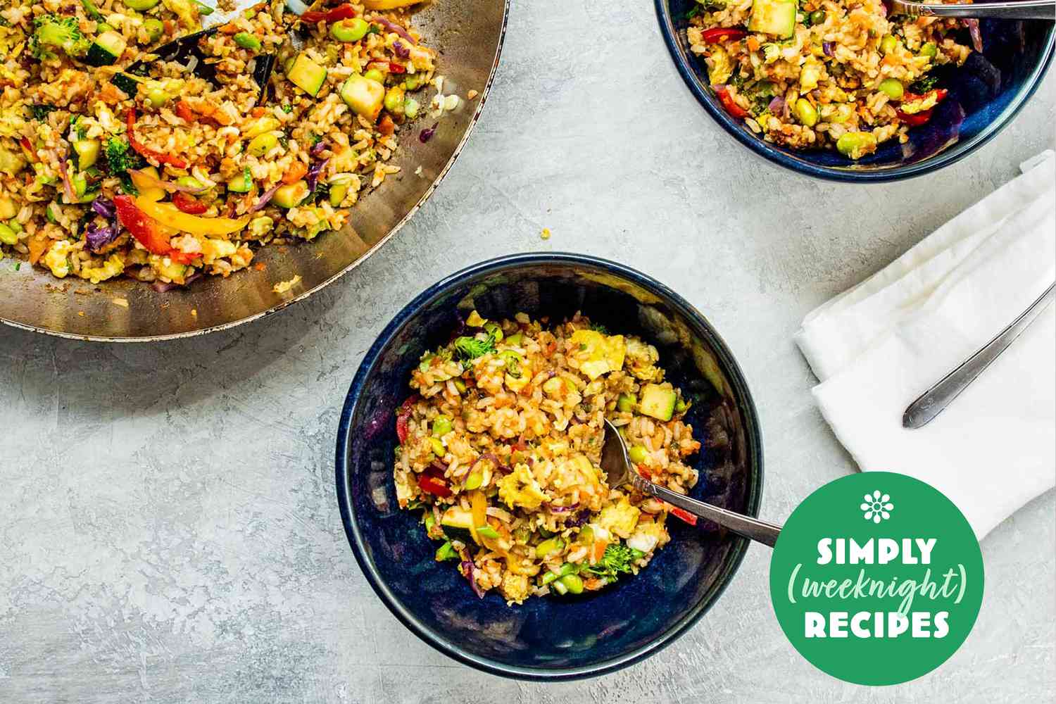 Vegetable fried rice in a blue bowl with a fork