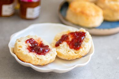 A scone split in half with jam spread on both sides