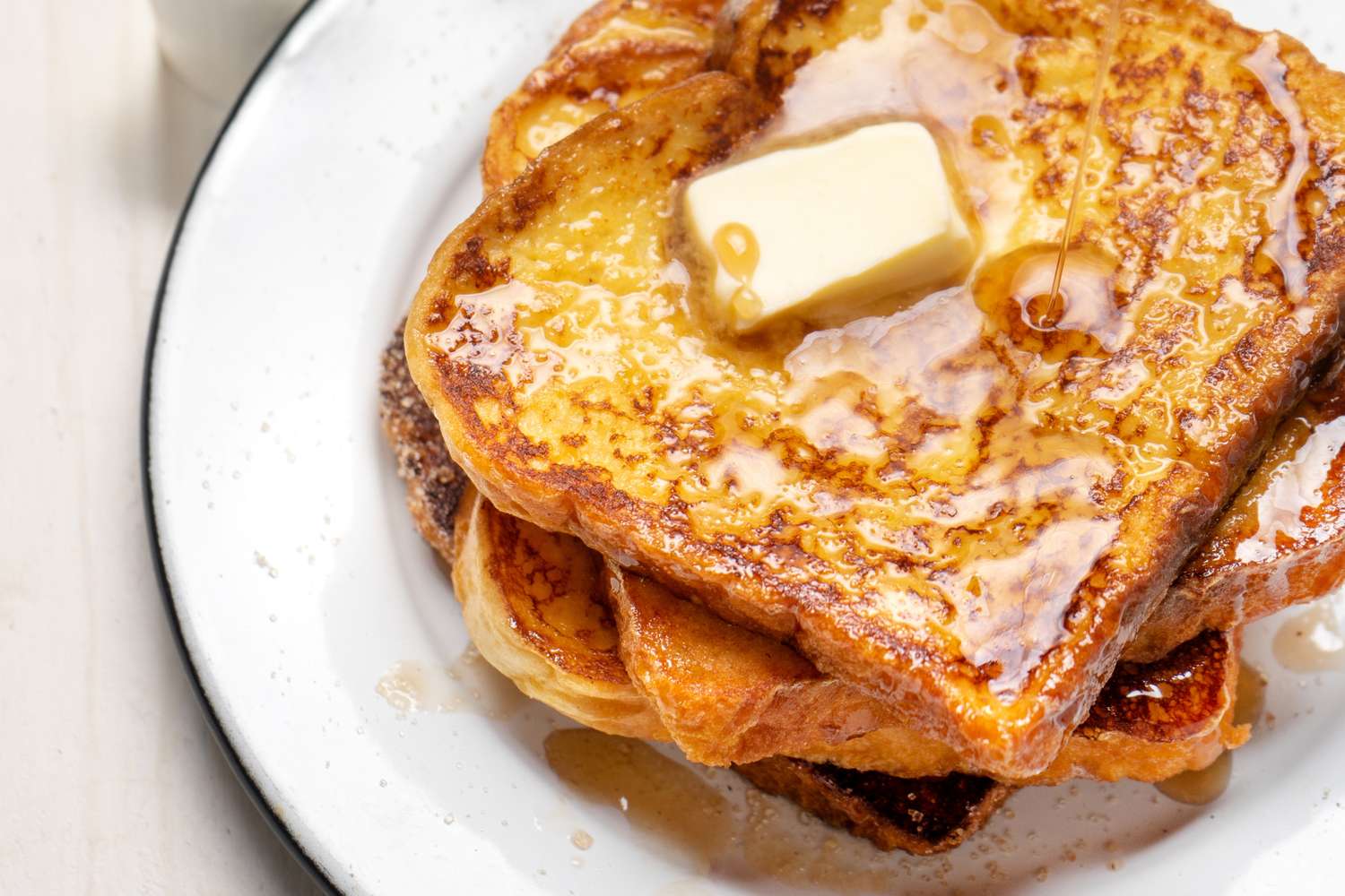 A plate of French toast topped with butter and syrup