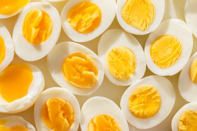 Hardboiled eggs sliced in half displaying yolks in varying consistencies arranged closely together