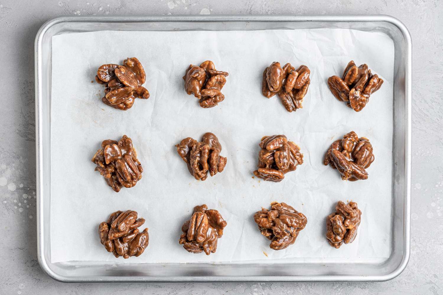 Overhead view of a baking sheet of praline candy.