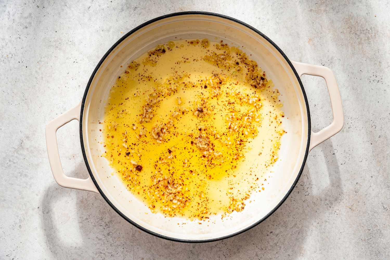 Garlic and chili flakes cooked in a large pot for assassin's spaghetti recipe