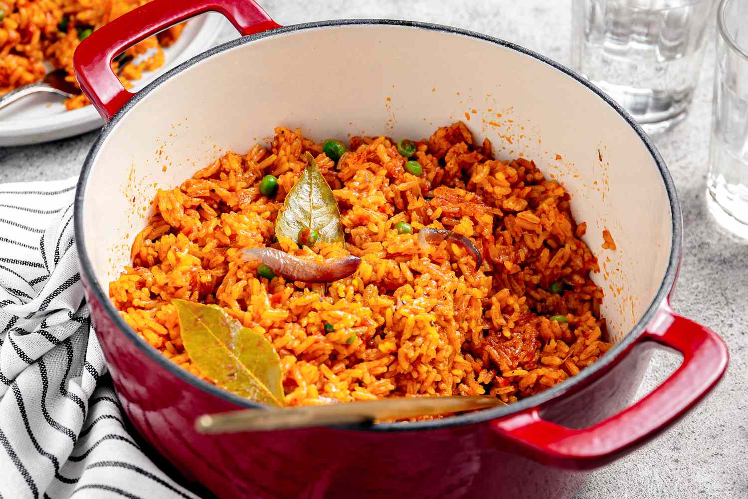 Jollof Rice in a Dutch Oven With a Serving on a Plate in the Background