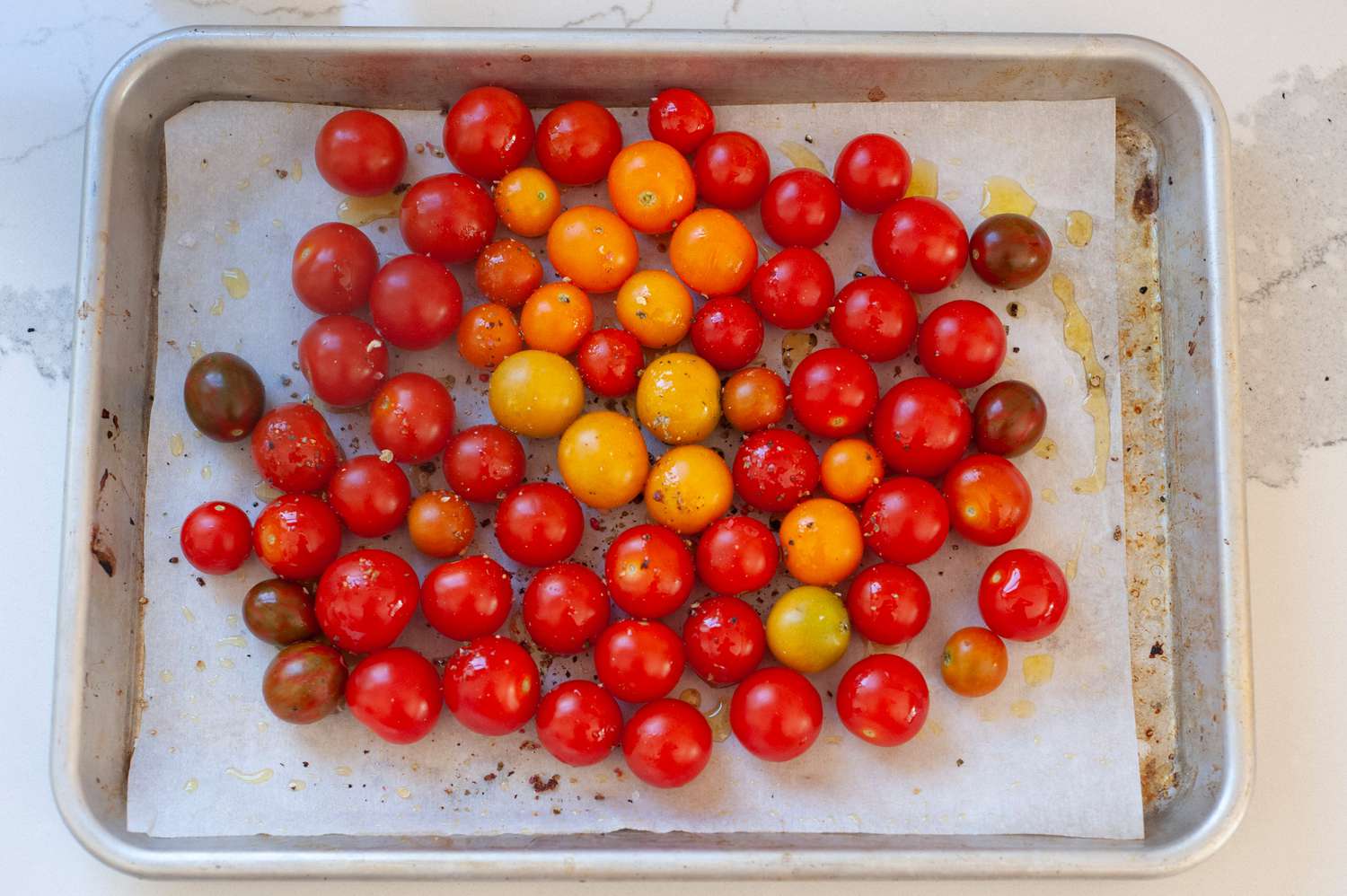 Cherry Tomatoes on a Tray with Cracked Pepper and Olive Oil for Roasted Tomatoes