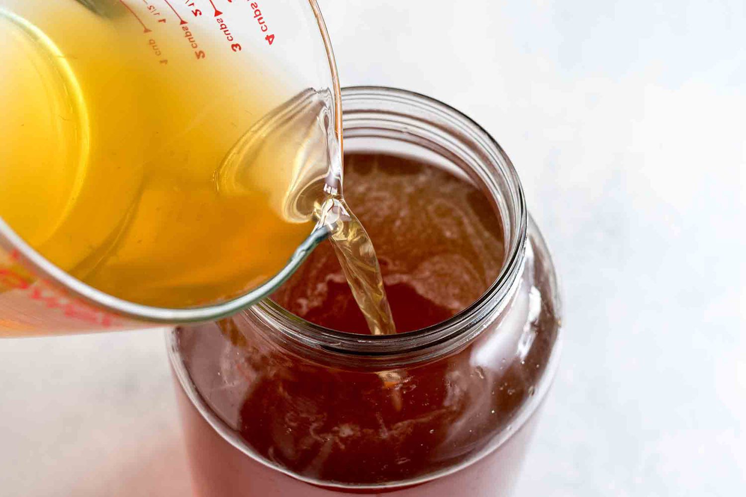 Add the prepared kombucha to the jar with the sweet tea for making kombucha at home