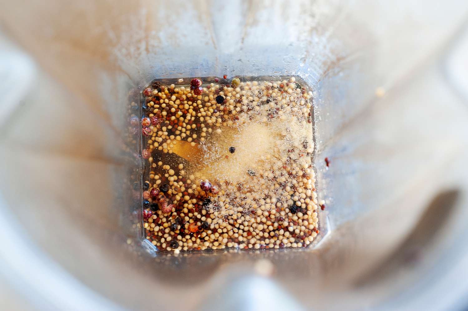 Blender with ingredients to make a honey mustard recipe.