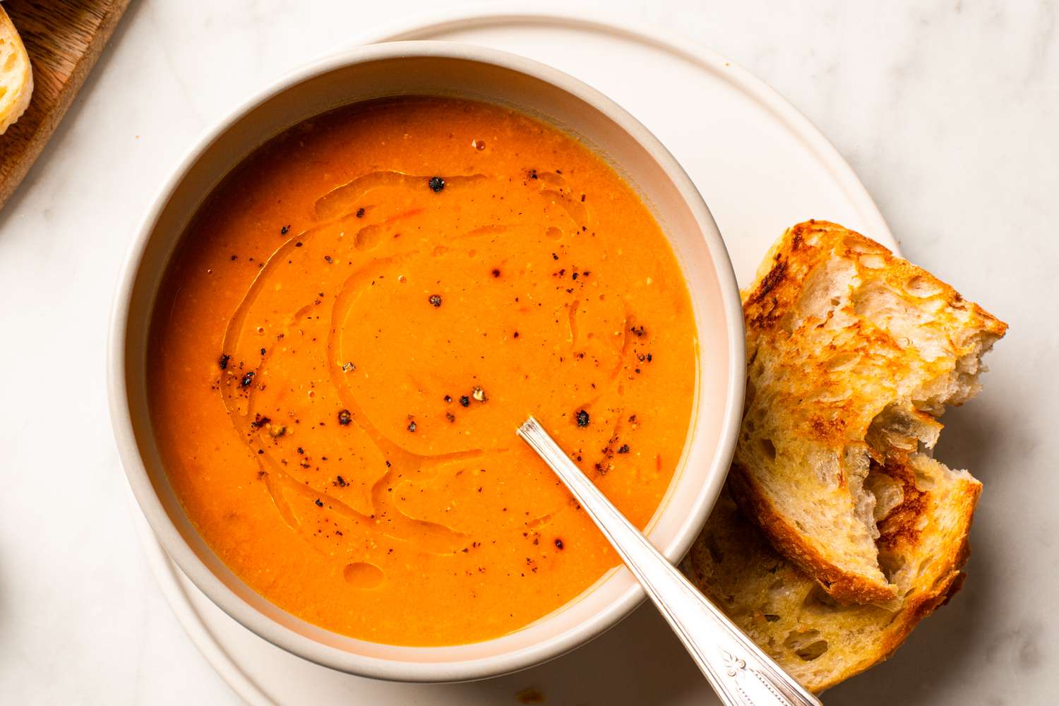 A bowl of soup accompanied by a piece of bread
