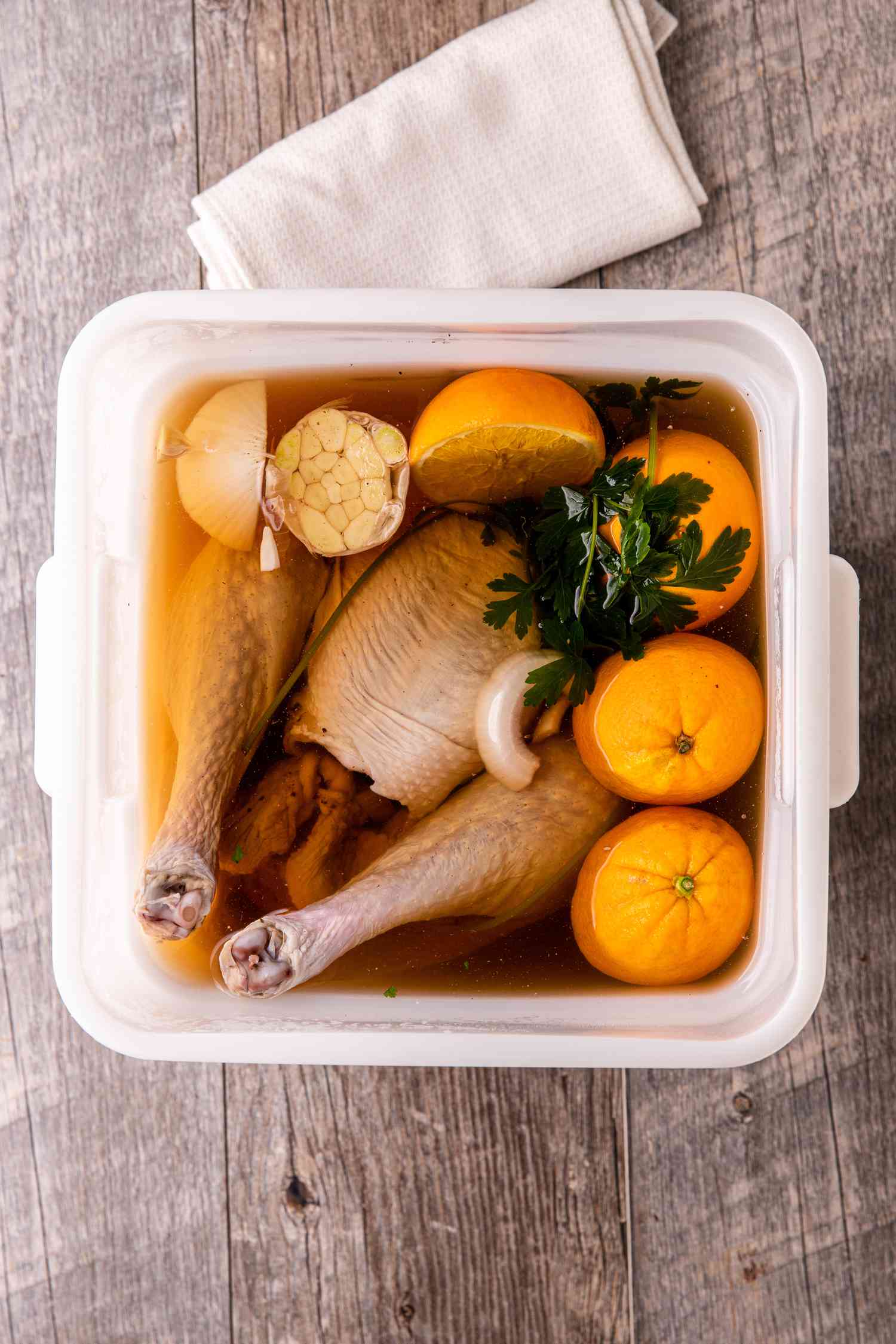 Brined whole turkey in a bucket with brining liquid.