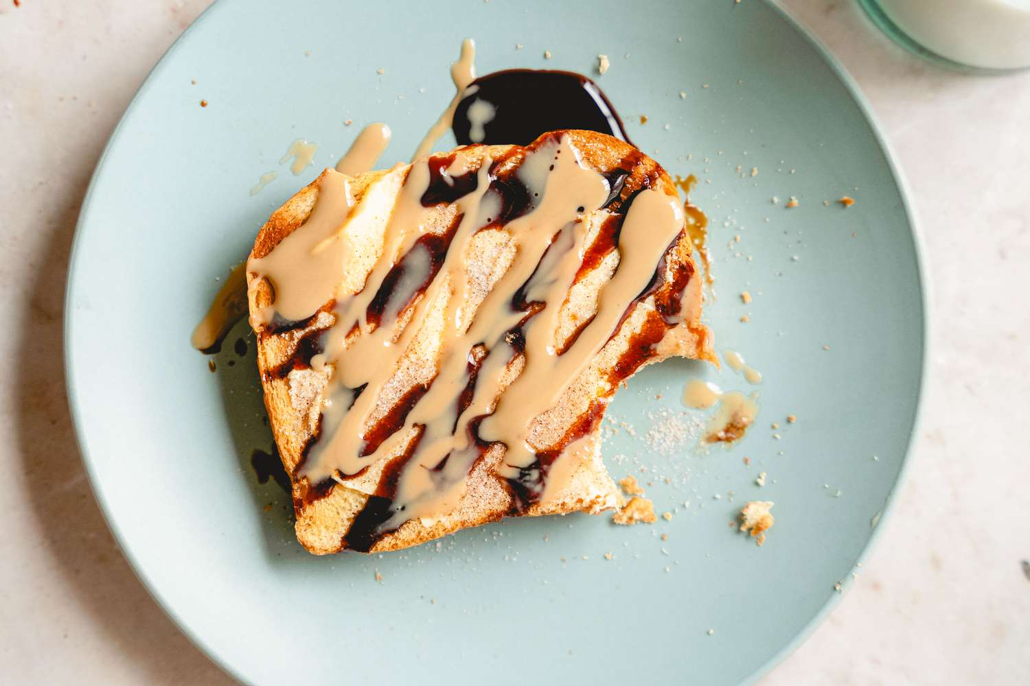 Plate of Tahini Cinnamon Toast with one bite taken out of it