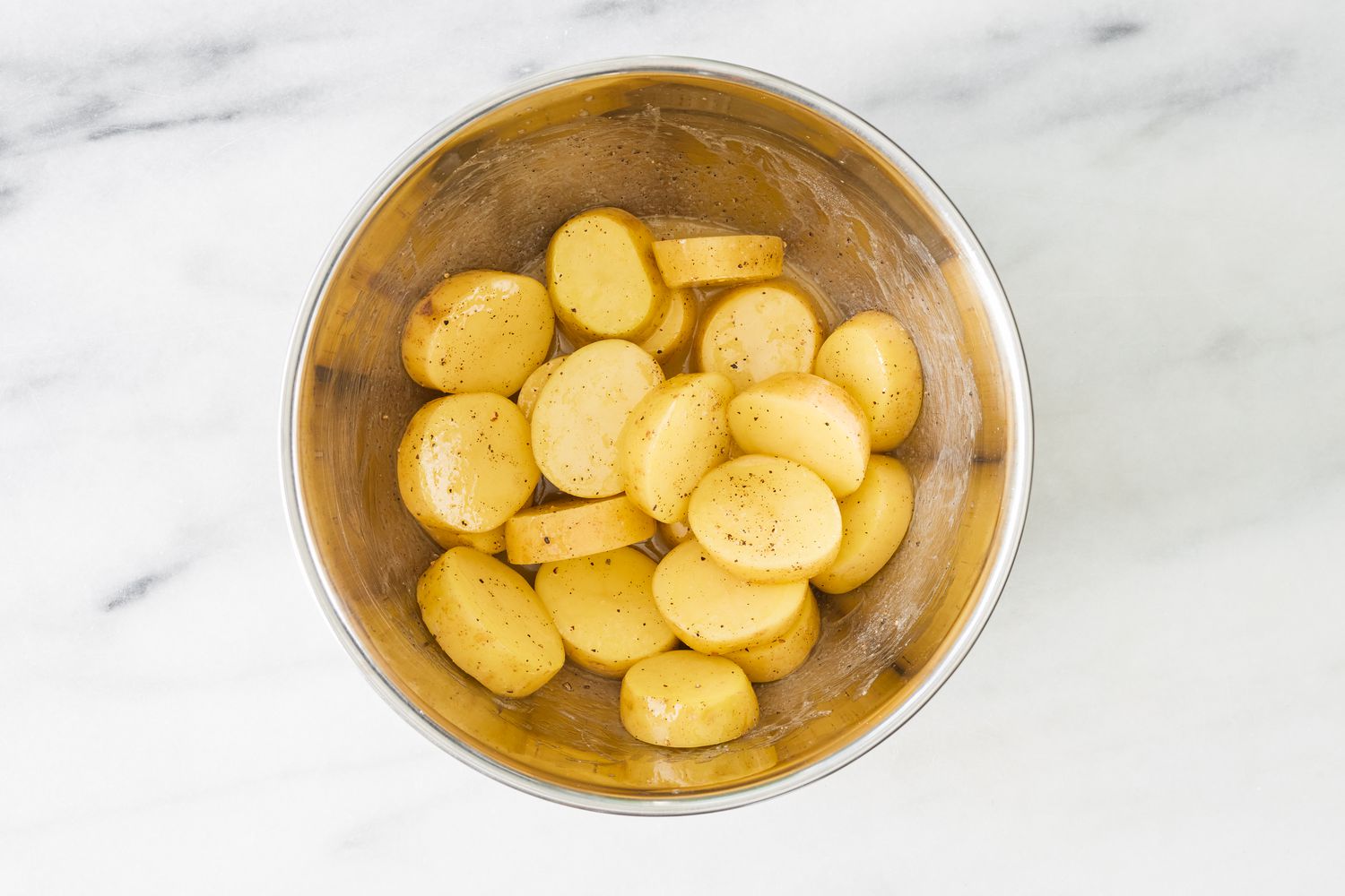 Sliced potatoes in a mixing bowl for the miso melting potatoes recipe
