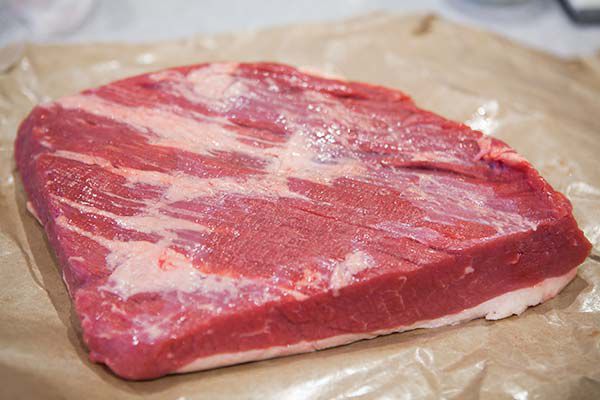 A cut of beef resting on parchment paper