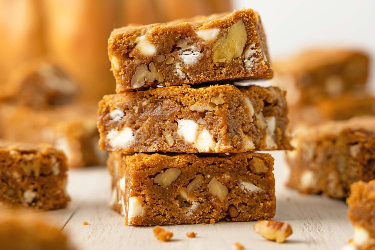 Stack of pumpkin blondies with white chocolate and nuts