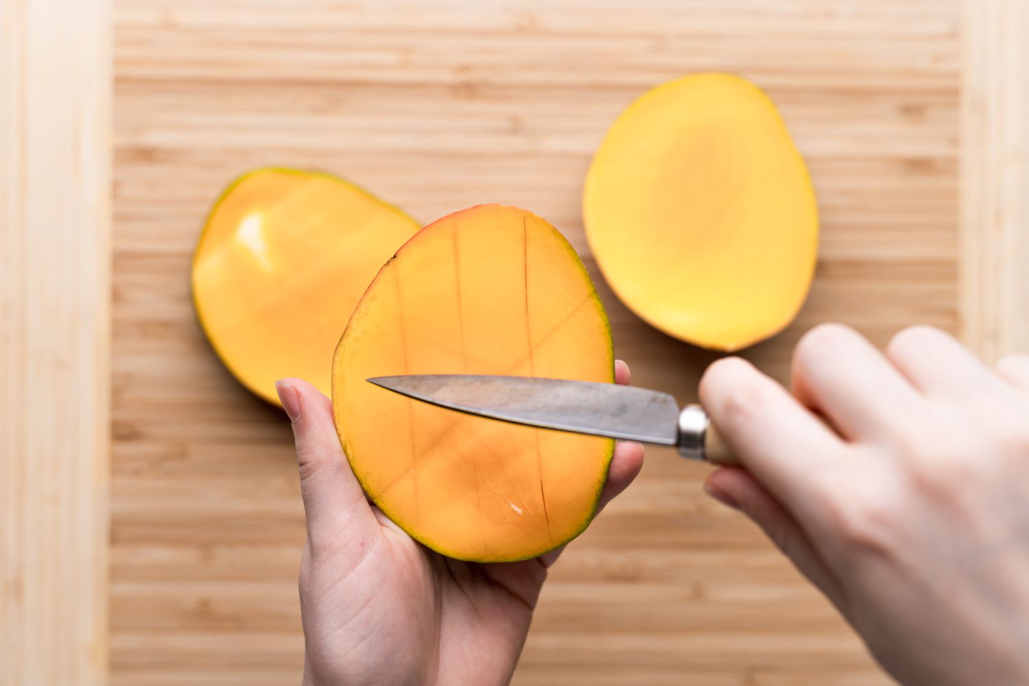 Making crosscuts into a mango to show how to cut a mango.