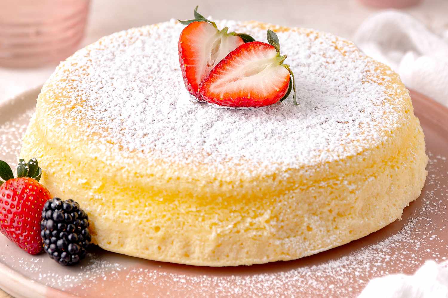 Japanese Cheesecake on a Plate and Garnished With Powdered Sugar and Berries