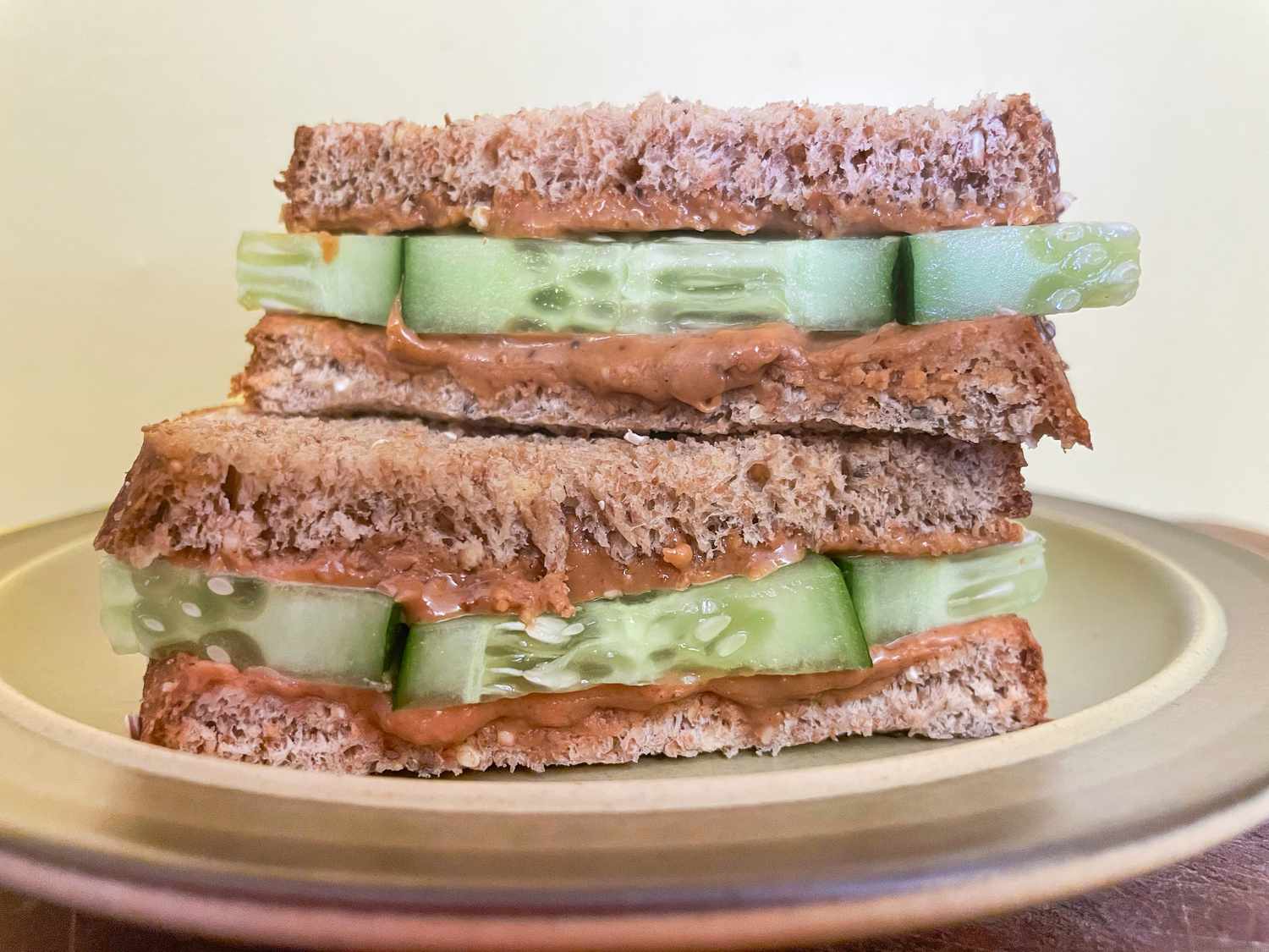 peanut butter and cucumber sandiwch stacked on a plate