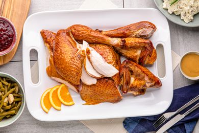 Citrus-brined smoked turkey carved on a platter.